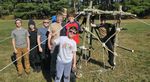 several scouts with a structure made of rope and logs