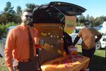 people in costume with a table by a car with an open trunk