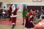 people dressed as Santa and Mrs. Claus greet people