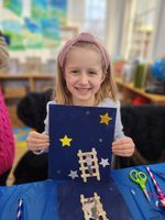 a girl holds a star-themed art project