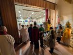 a view looking from backstage; people dressed as pageant characters