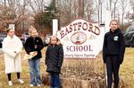 a group of students in front of the sign