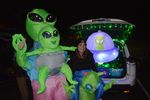 people dressed in alien costumes with their open car trunk decorated with an alien theme