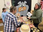 one woman buys a cake from another