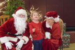 a child with Santa and Mrs. Claus