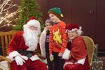 two children posing with Santa and Mrs. Claus