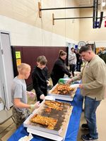 students serving food and beverages at a table