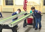 cub scouts blowing to propell toy boats down gutters with their breath