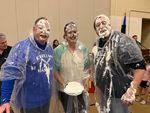 three people in ponchos covered in pie filling
