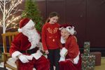a child with Santa and Mrs. Claus