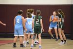 children in blue uniforms play against children in green uniforms